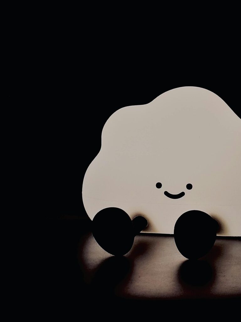 Adorable cloud-shaped lamp with a friendly smile, perfect for children's room decor.